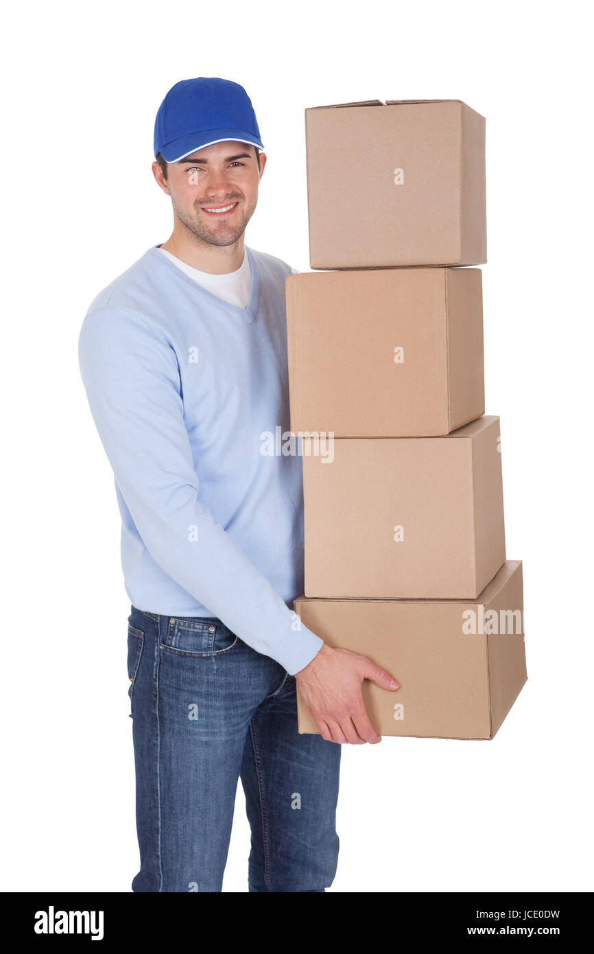 Smiling young delivery man holding stack of boxes. Isolated on white ...