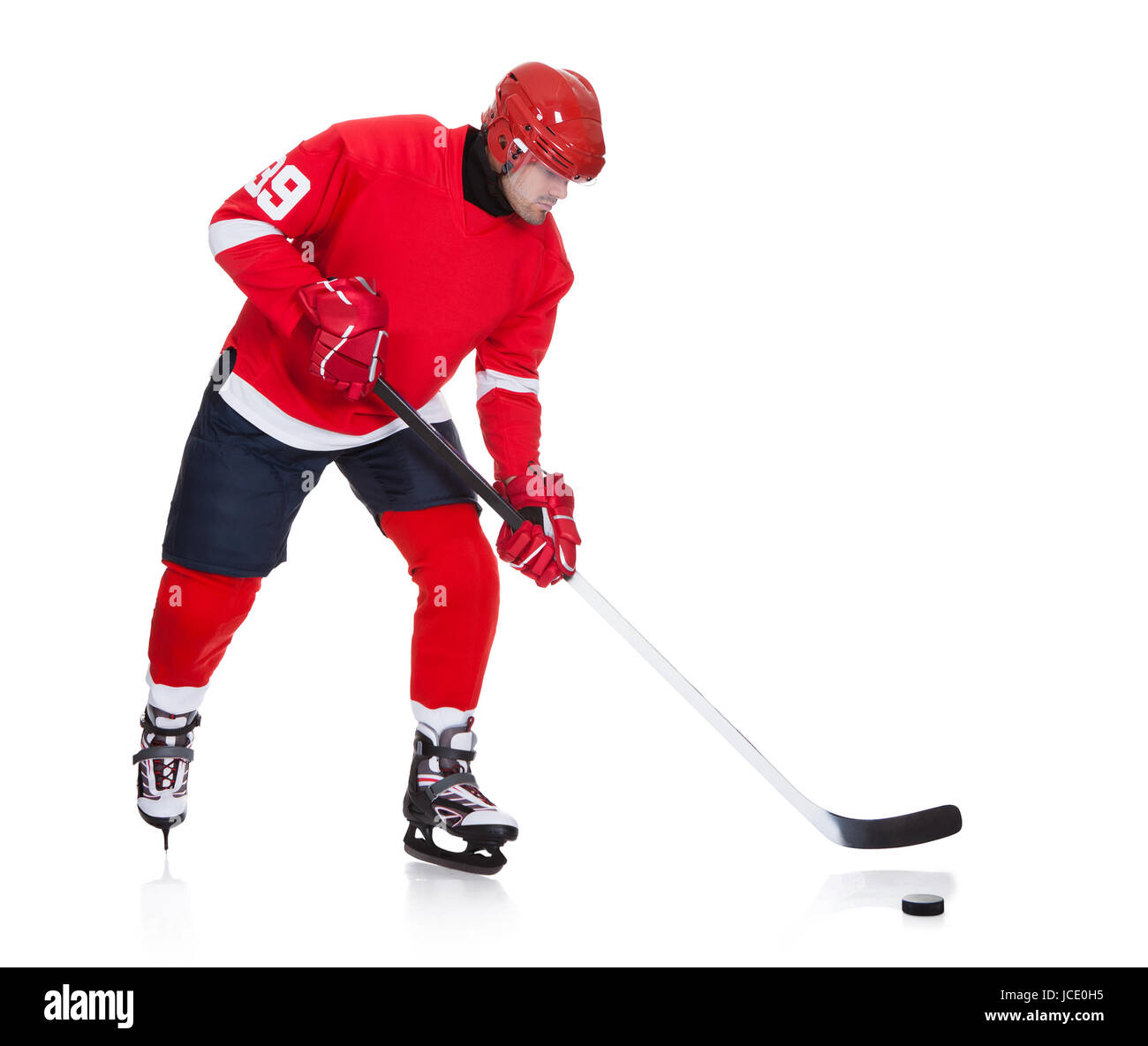Professional hockey player skating on ice. Isolated on white Stock