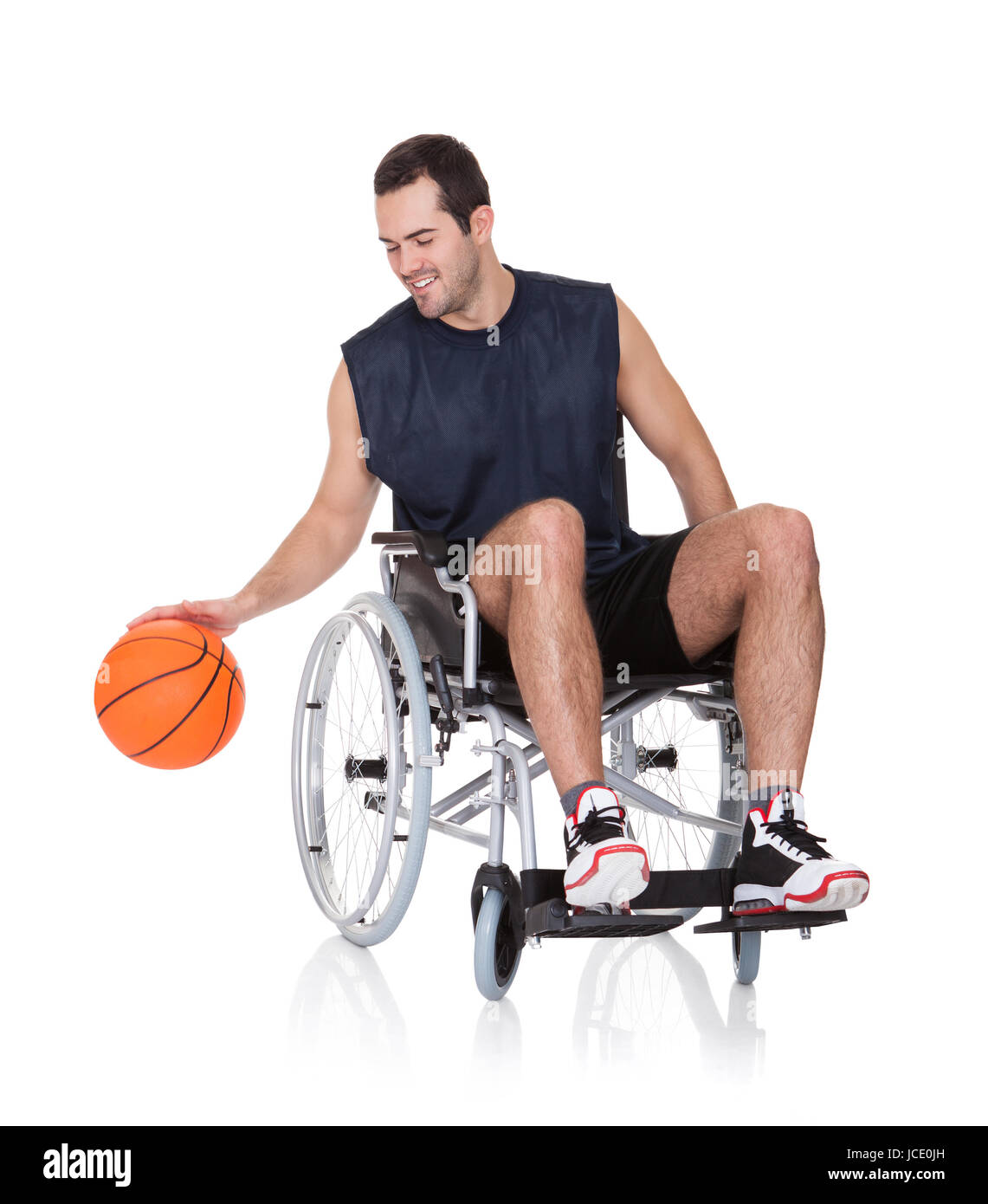 Man in wheelchair playing basketball. Isolated on white Stock Photo