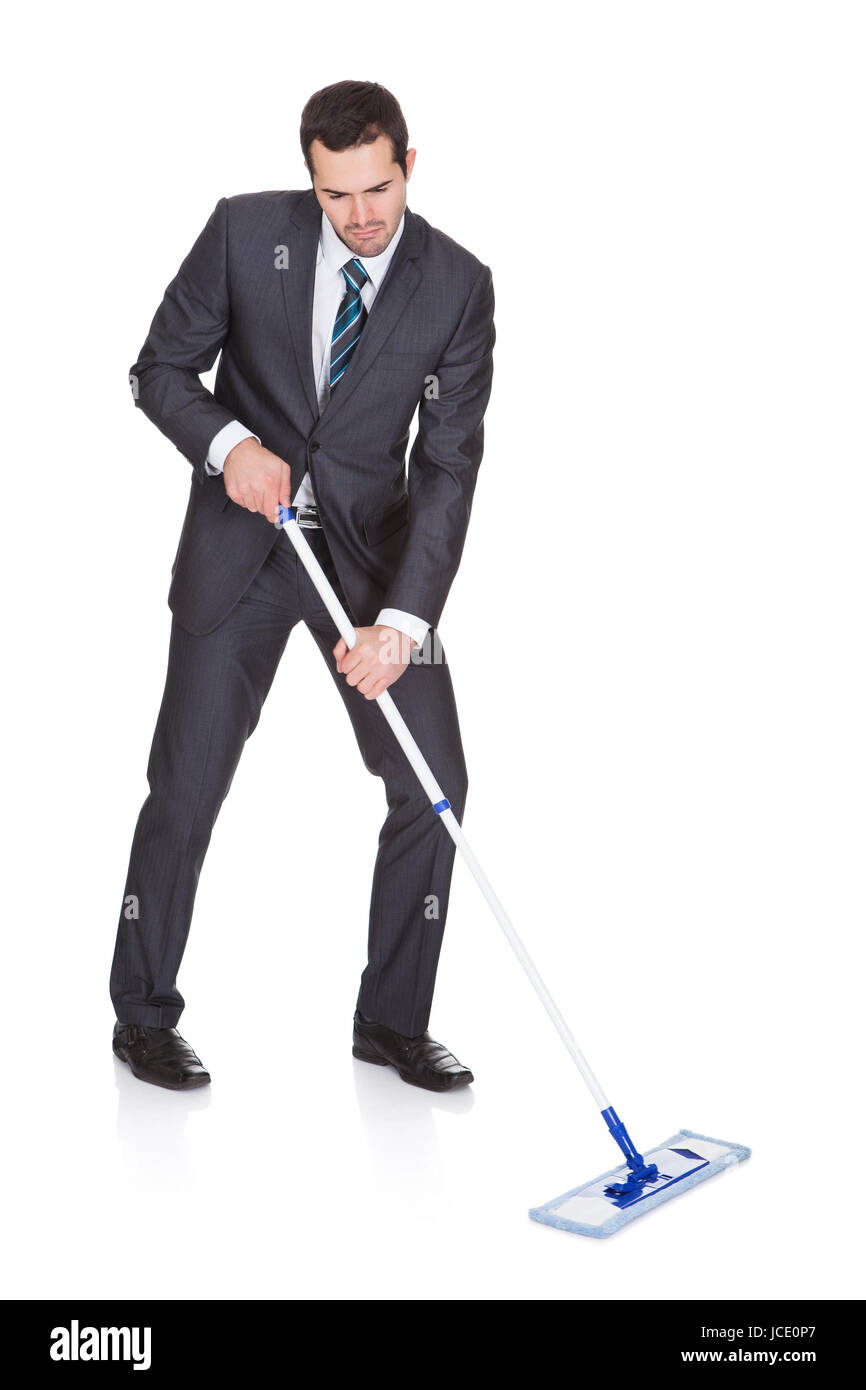 Businessman cleaning floor. Isolated on white background Stock Photo