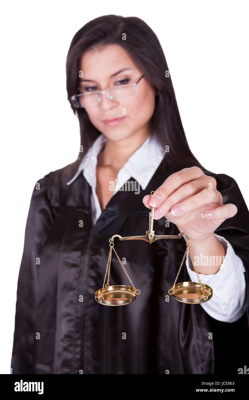 Beautiful serious female judge in a gown holding up a brass hanging