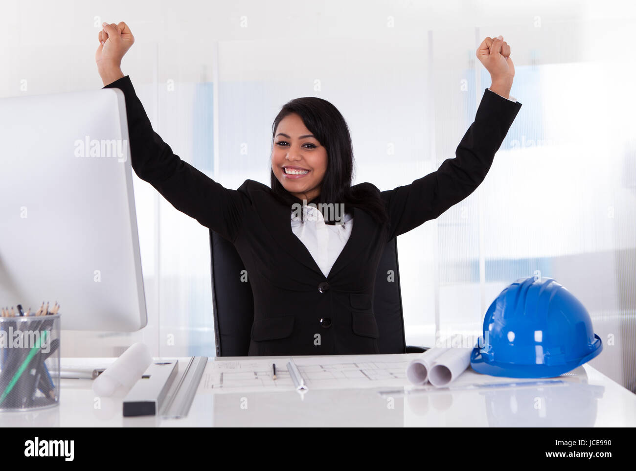 Portrait Of Young Excited Female Architect With Hand Raised Stock Photo
