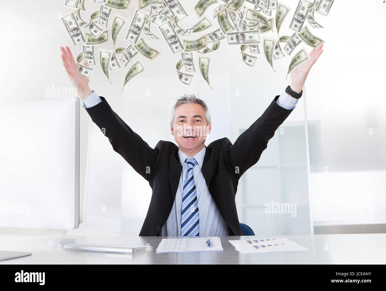 Happy Mature Businessman Raising Arms At Desk In Office Stock Photo - Alamy