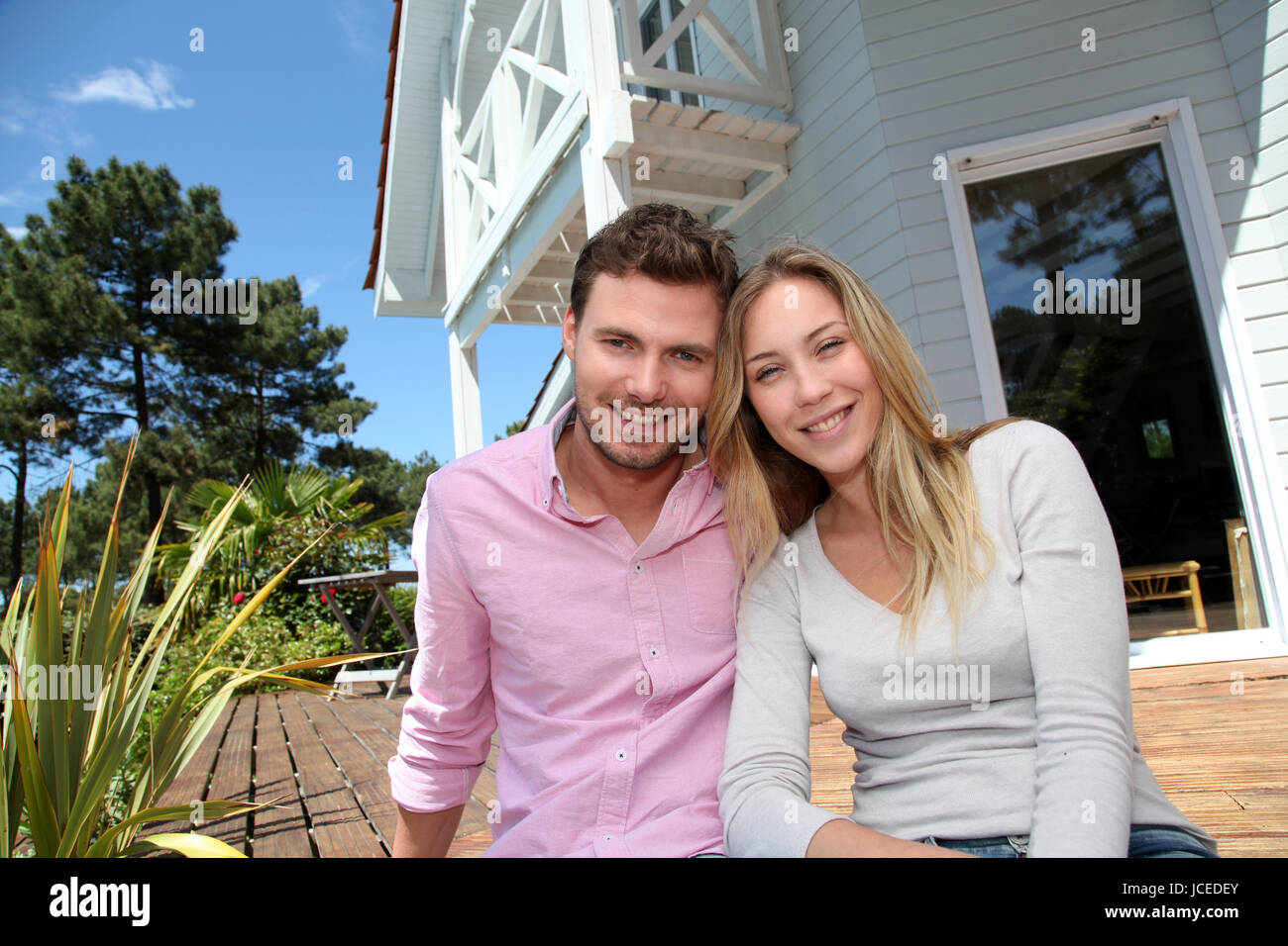 Portrait of smiling couple standing in front of house Stock Photo