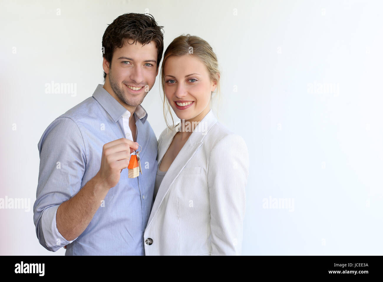 Young smiling couple holding keys of their new house Stock Photo - Alamy