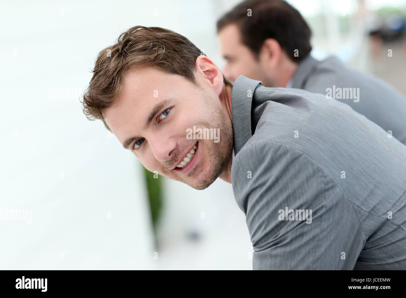 Portrait of smiling businessman leaning on wall Stock Photo - Alamy