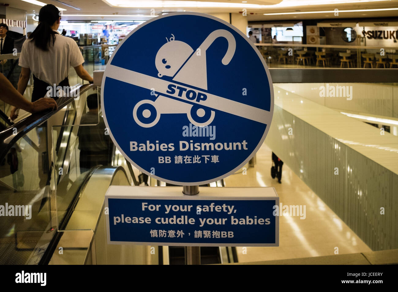 Sign in front of escalator promoting safety of babies in strollers Stock Photo