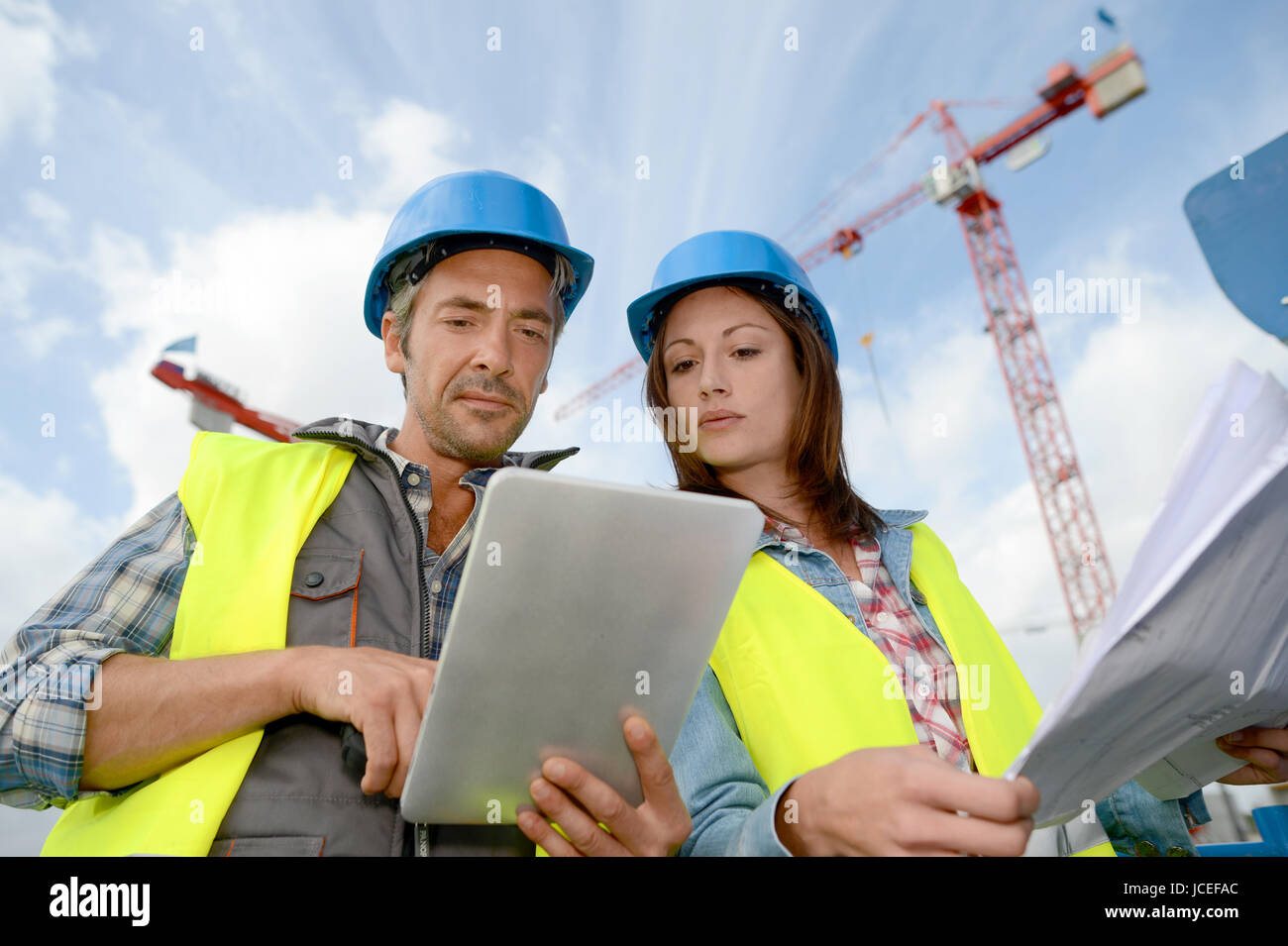 Construction manager and engineer working on building site Stock Photo ...