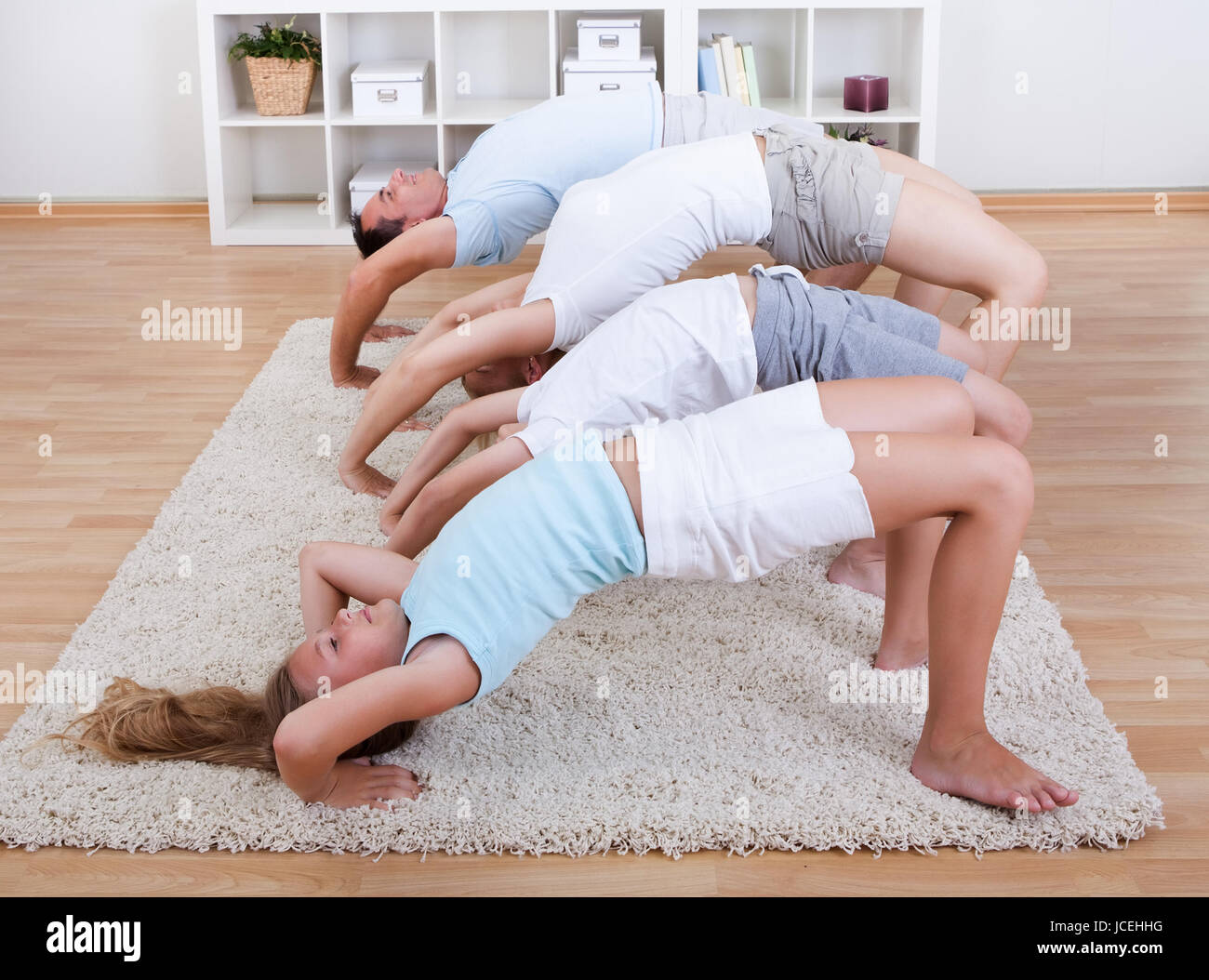 Family Doing Stretching Exercises Laying On The Carpet At Home Stock
