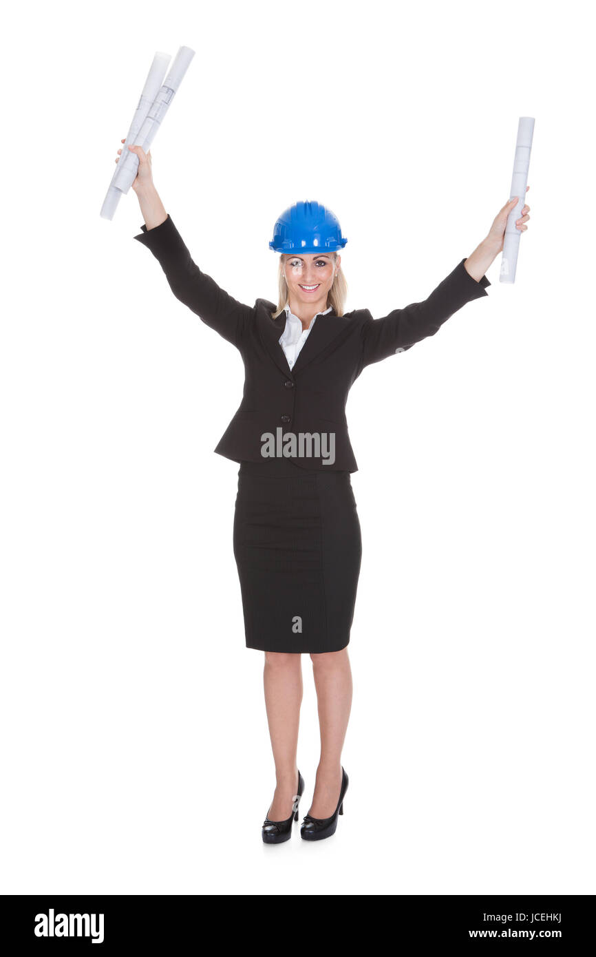 Portrait Of Excited Female Architect Holding Blueprint Over White Background Stock Photo