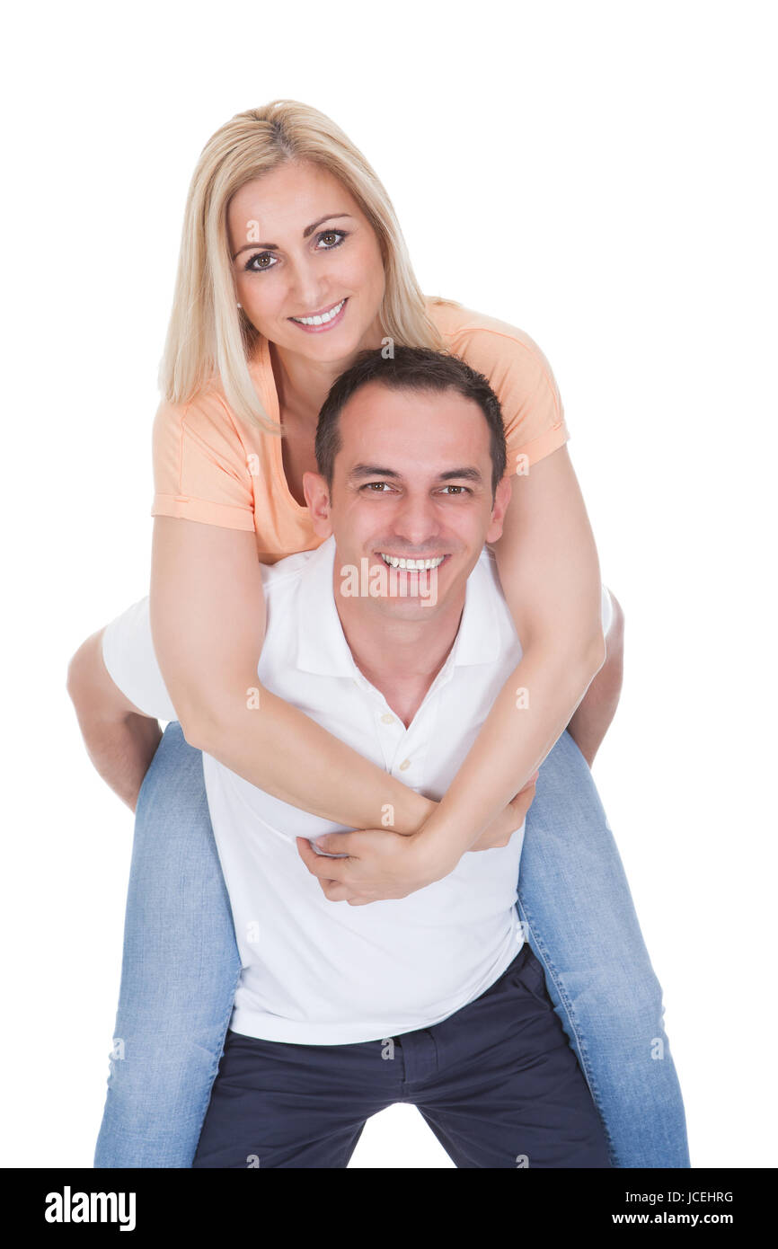 Attractive Man Piggybacking His Pretty Girlfriend Isolated Over White Background Stock Photo