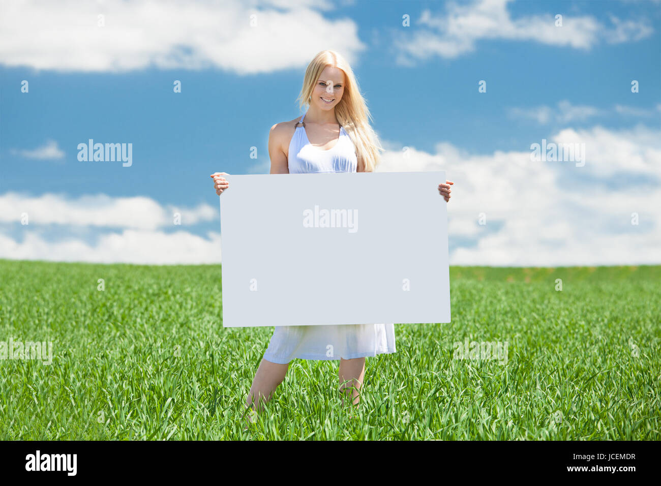 Happy Young Woman Standing In Field Holding Placard Stock Photo - Alamy