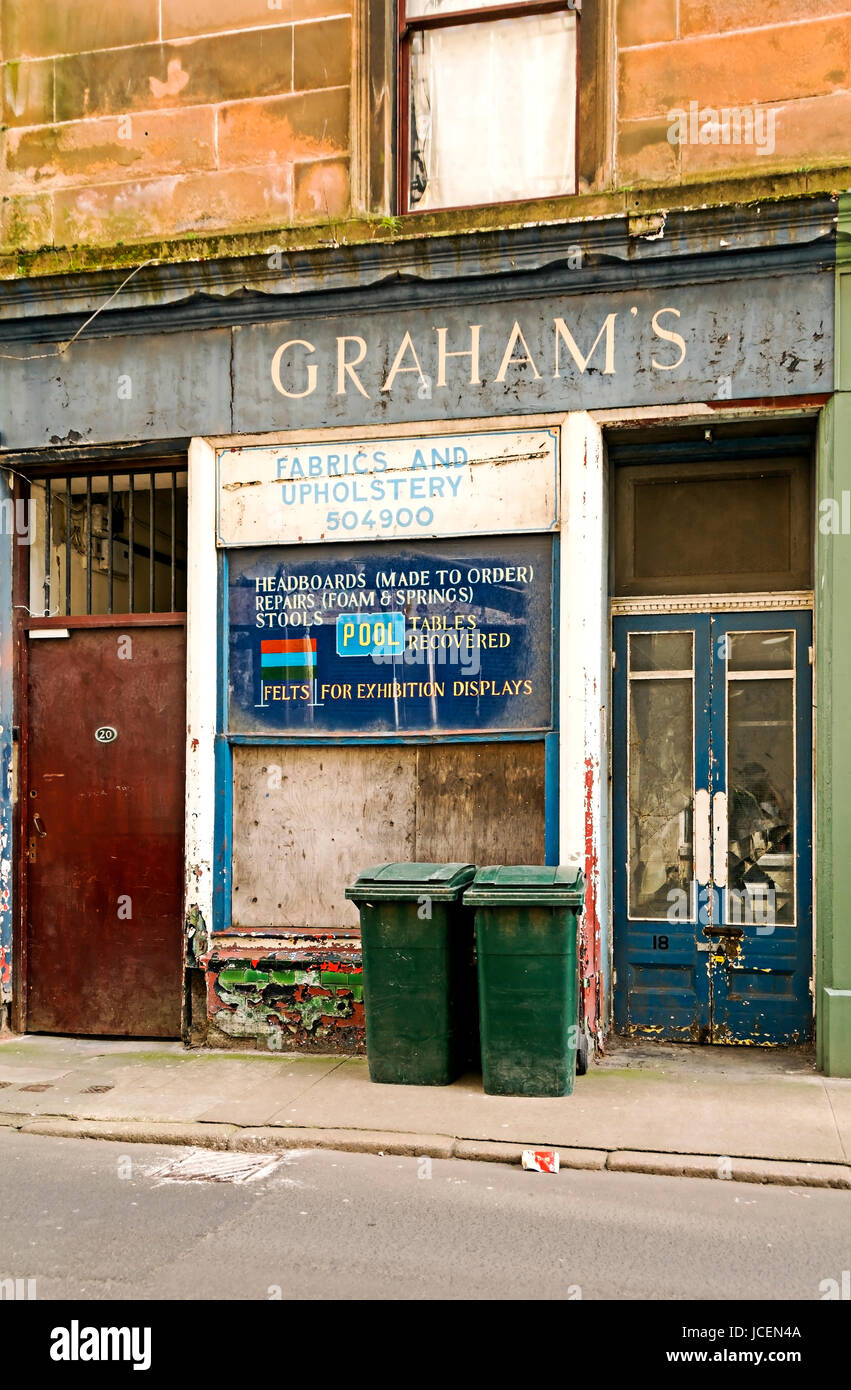 This upholstery shop has closed down and the shop front is badly decayed. Stock Photo