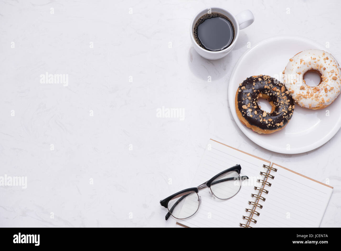 Working desk with dessert and coffee. Cake donuts with a cup of espresso on marble table top. Stock Photo