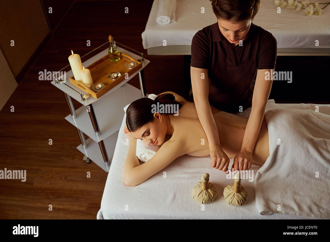 Massage of young woman lying in spa salon Stock Photo