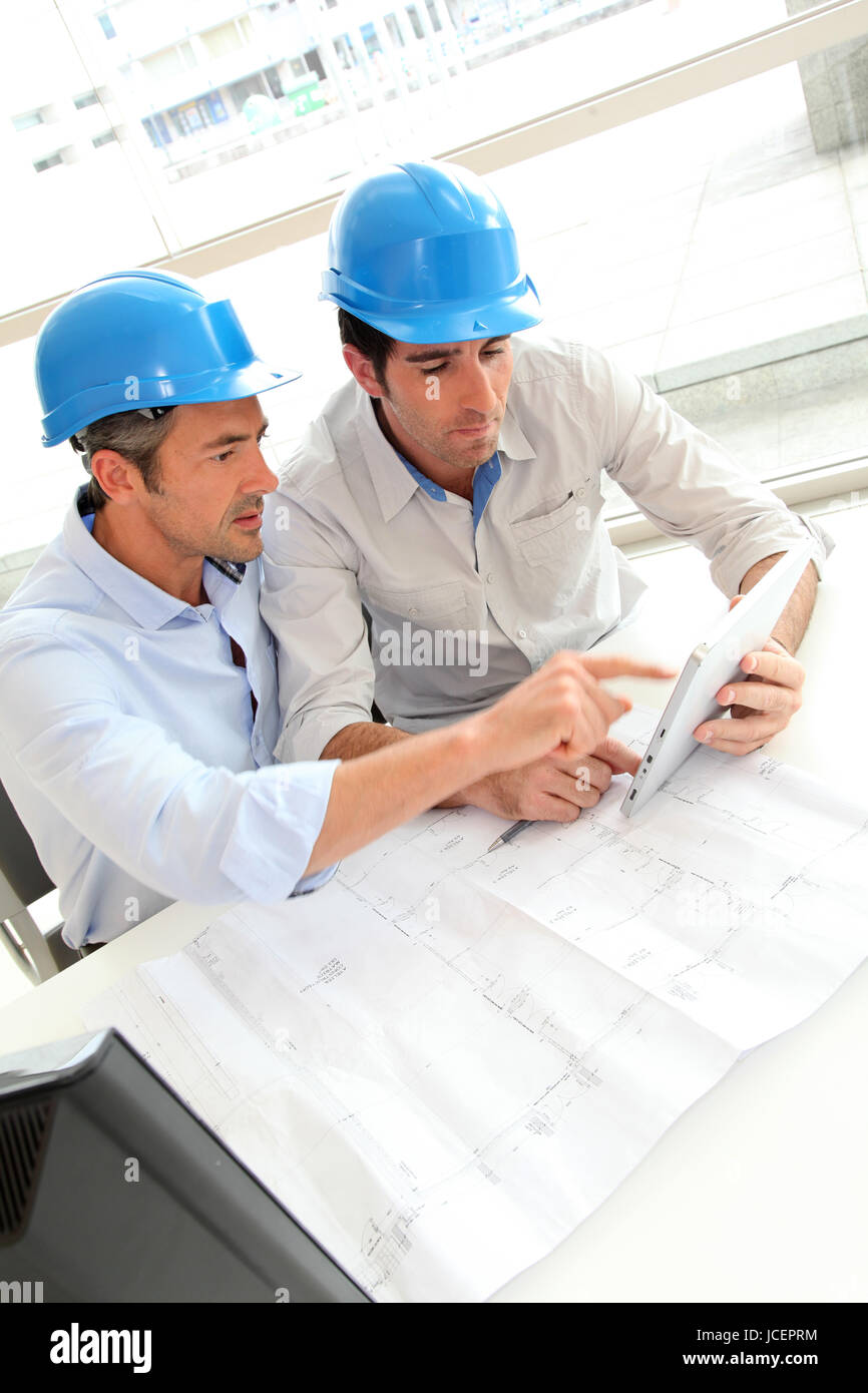 Architects working on construction plan Stock Photo Alamy