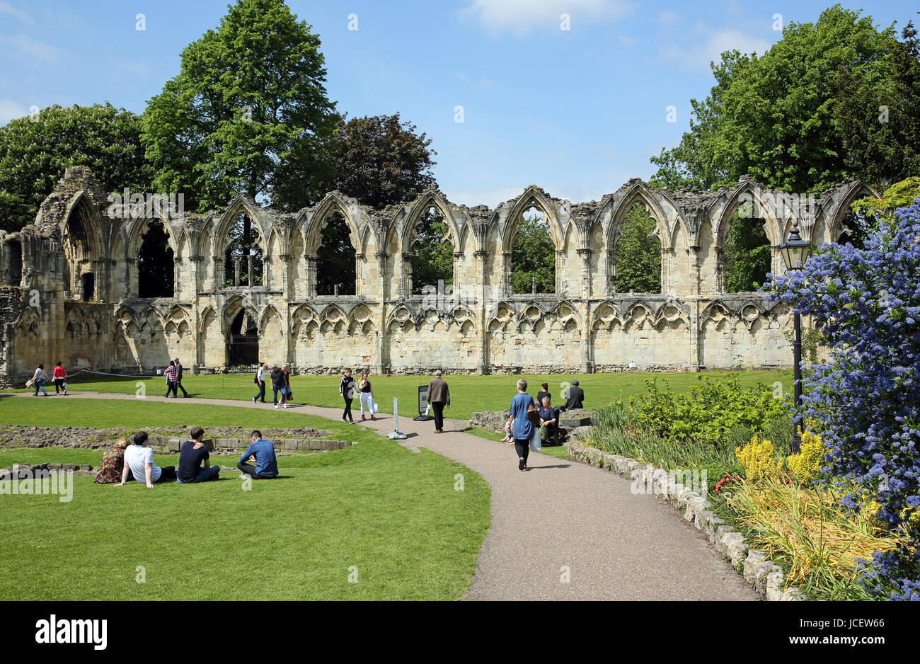 The ruins of St. Mary's Abbey in York, England, UK, with holiday makers in the foreground enjoying the sunshine. Stock Photo