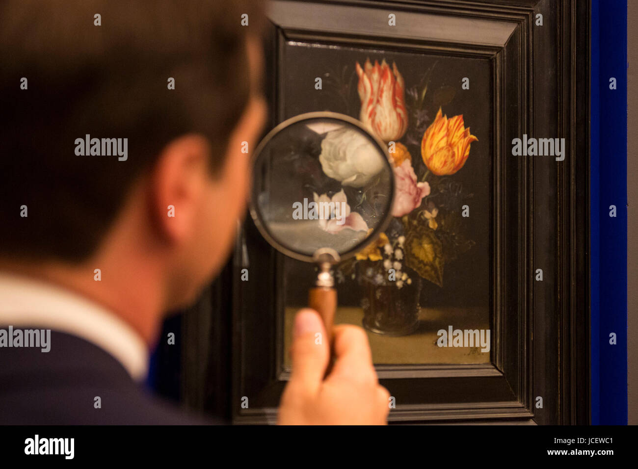 London, UK. 15 June 2017. A Sotheby's employee takes a close look at Still Life with Flowers by Ambrosius Bosschaert the Elder, circa 1608-10, estimate GBP 2 to 3 million. Auction house Sotheby's presents Actual Size, a curated evening sale on 21 June 2017. Stock Photo