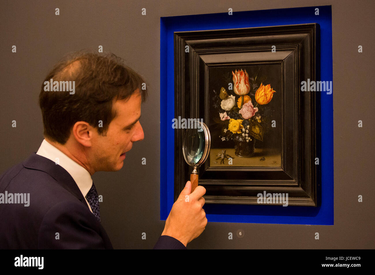 London, UK. 15 June 2017. A Sotheby's employee takes a close look at Still Life with Flowers by Ambrosius Bosschaert the Elder, circa 1608-10, estimate GBP 2 to 3 million. Auction house Sotheby's presents Actual Size, a curated evening sale on 21 June 2017. Stock Photo