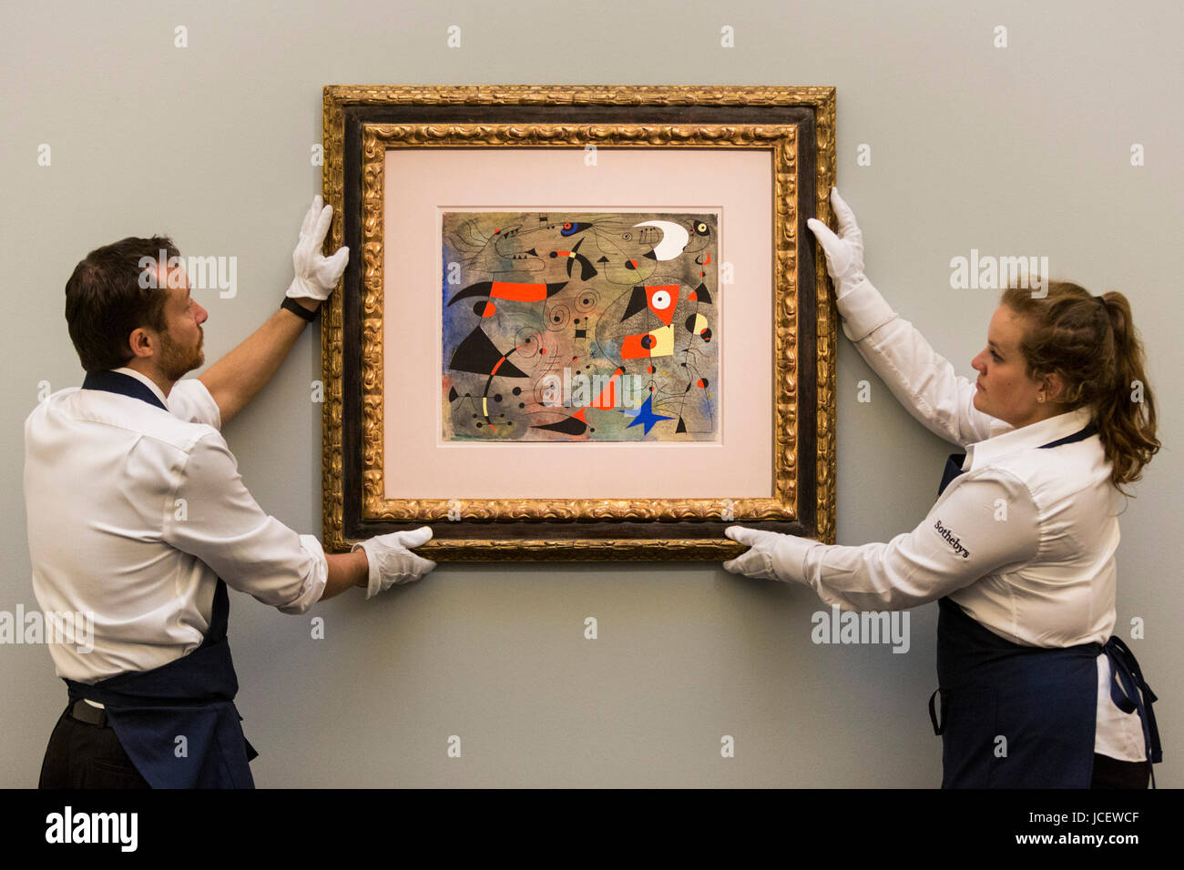 London, UK. 15 June 2017. Sotheby's technicians hang the painting Femme et oiseaux, 1940, by Joan Miro, estimate upon request Auction house Sotheby's presents Landmarks int he Development of Modern Art to lead Sotheby's Impressionist & Modern Art Evening Sale on 21 June 2017. Stock Photo