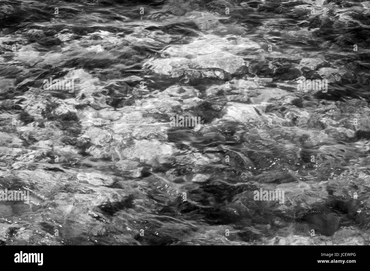 A Black and White image of the seabed seen through shallow water Stock ...