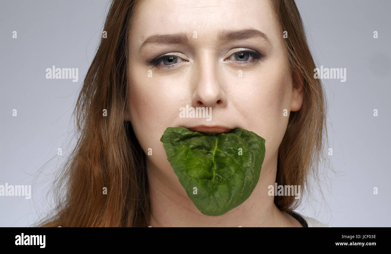Spinach leaf in female mouth Stock Photo Alamy