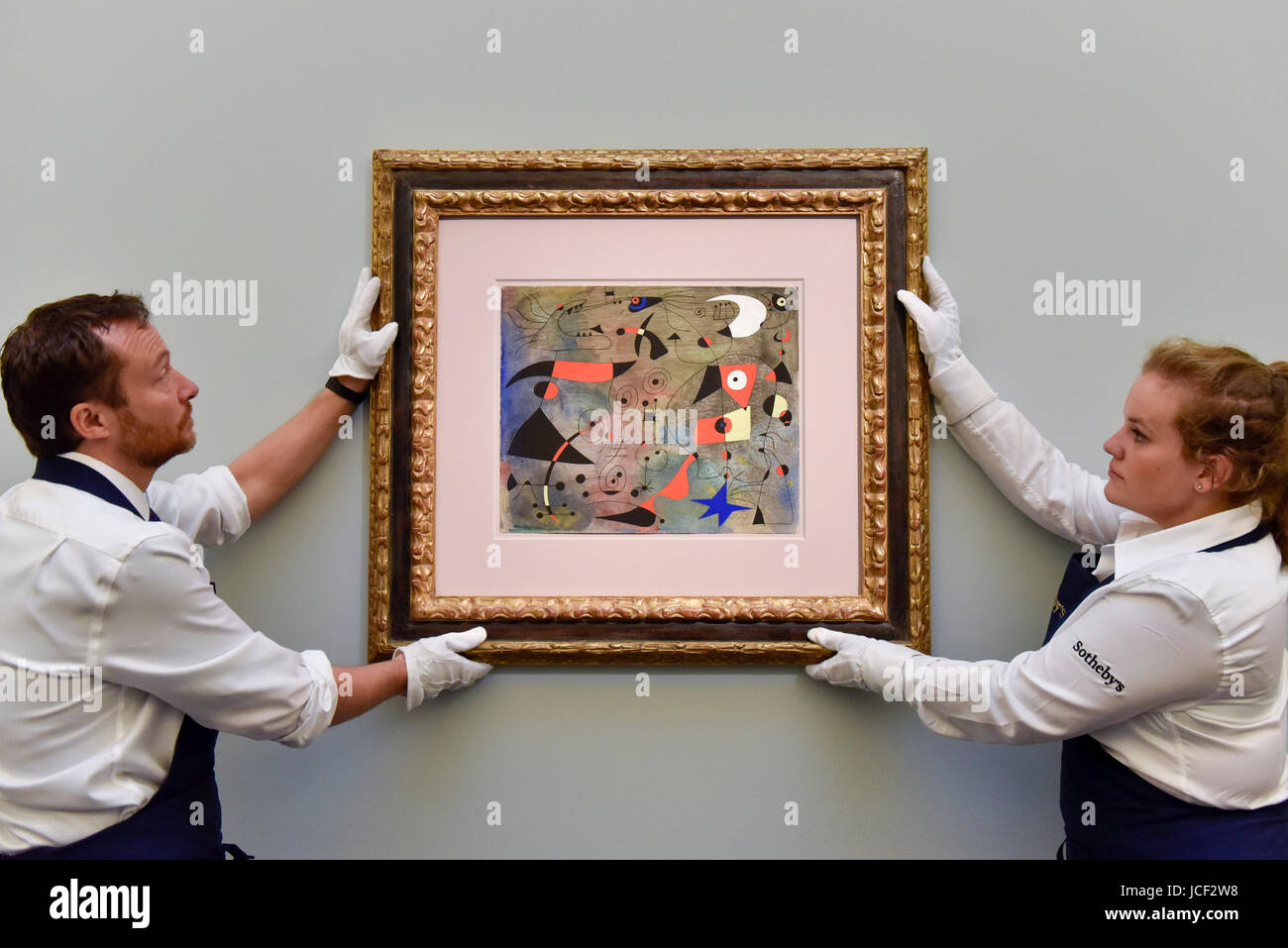 London, UK.  15 June 2017.  Technicians hang 'Femme et oiseaux', 1940, by Joan Miró (estimate on request).  Preview of Impressionist and Modern art sale, taking place at Sotheby's New Bond Street on 21 June. Credit: Stephen Chung / Alamy Live News Stock Photo
