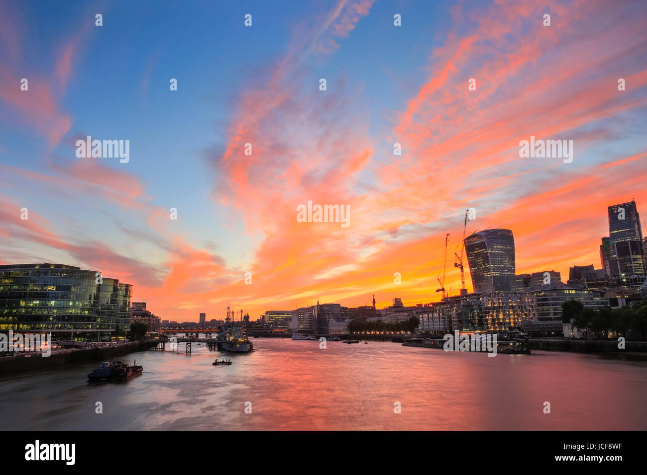 A beautifully sunny day ends with a stunning sunset sky in a panorama over City Hall, the Shard, City of London and the River Thames in London, UK Stock Photo