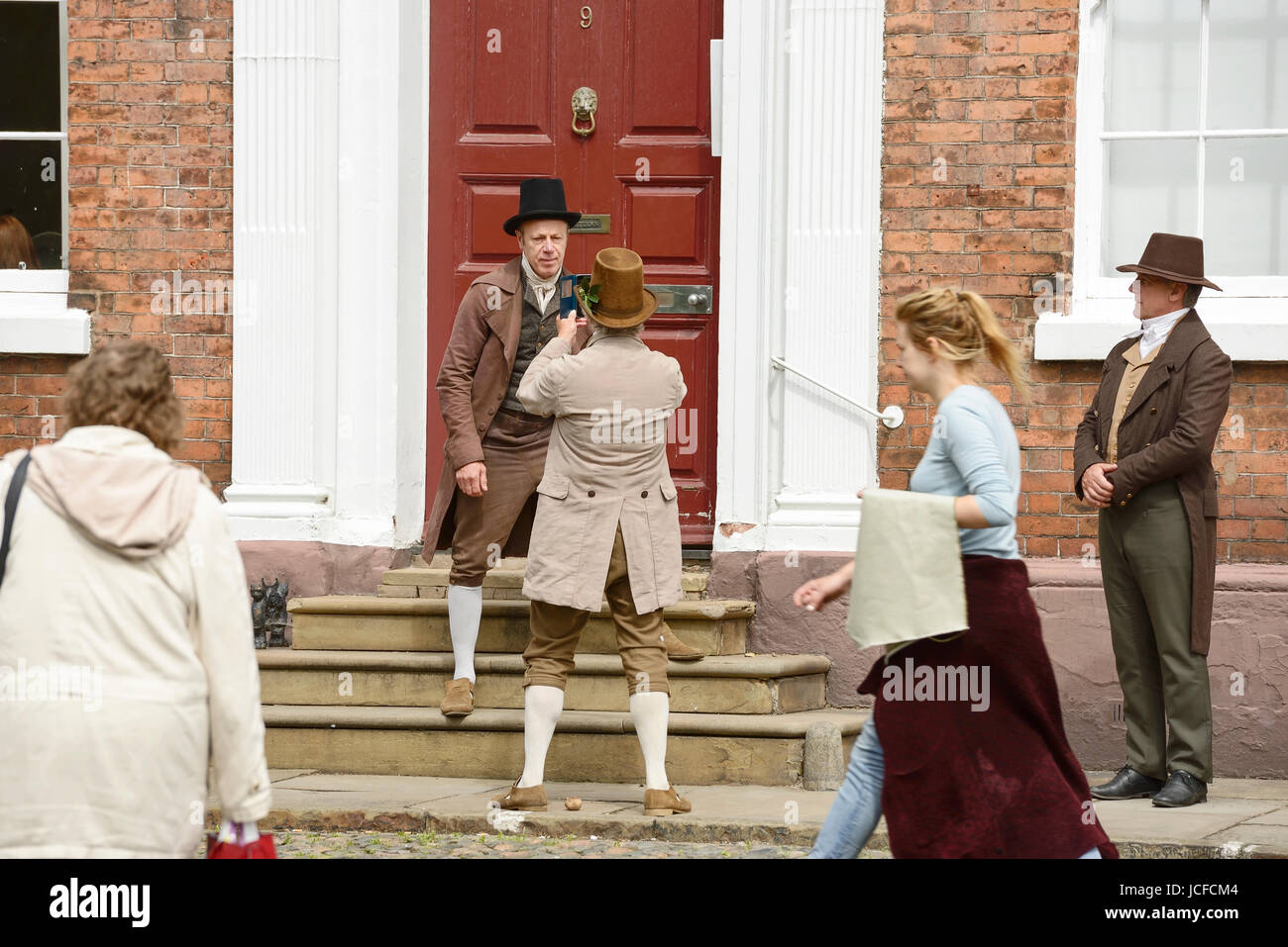 Chester, UK. 16th June, 2017. Actors in period costume take a break from filming the new Mike Leigh film Peterloo. Filming is taking place in Abbey Square and Chester Cathedral. Credit: Andrew Paterson/Alamy Live News Stock Photo