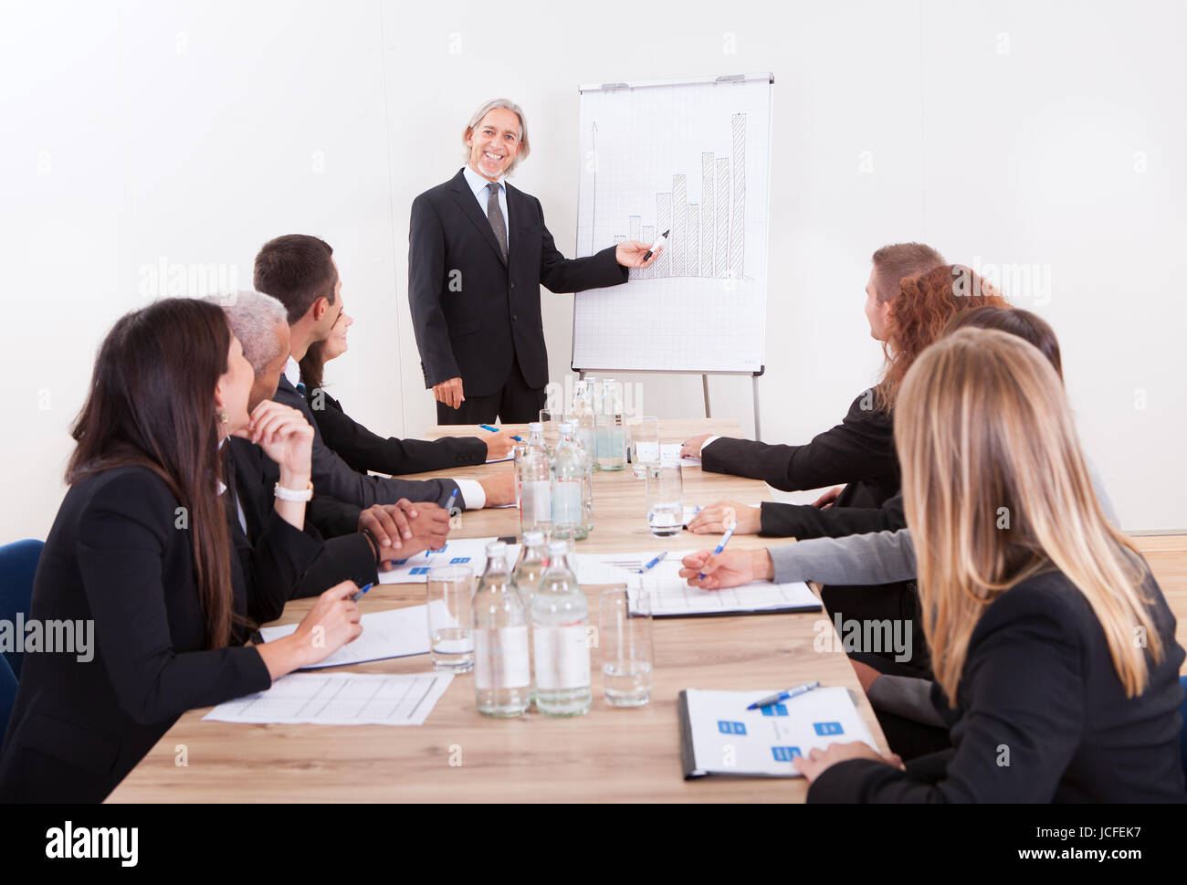 Portrait Of A Senior Manager Giving Presentation To His Colleagues At ...