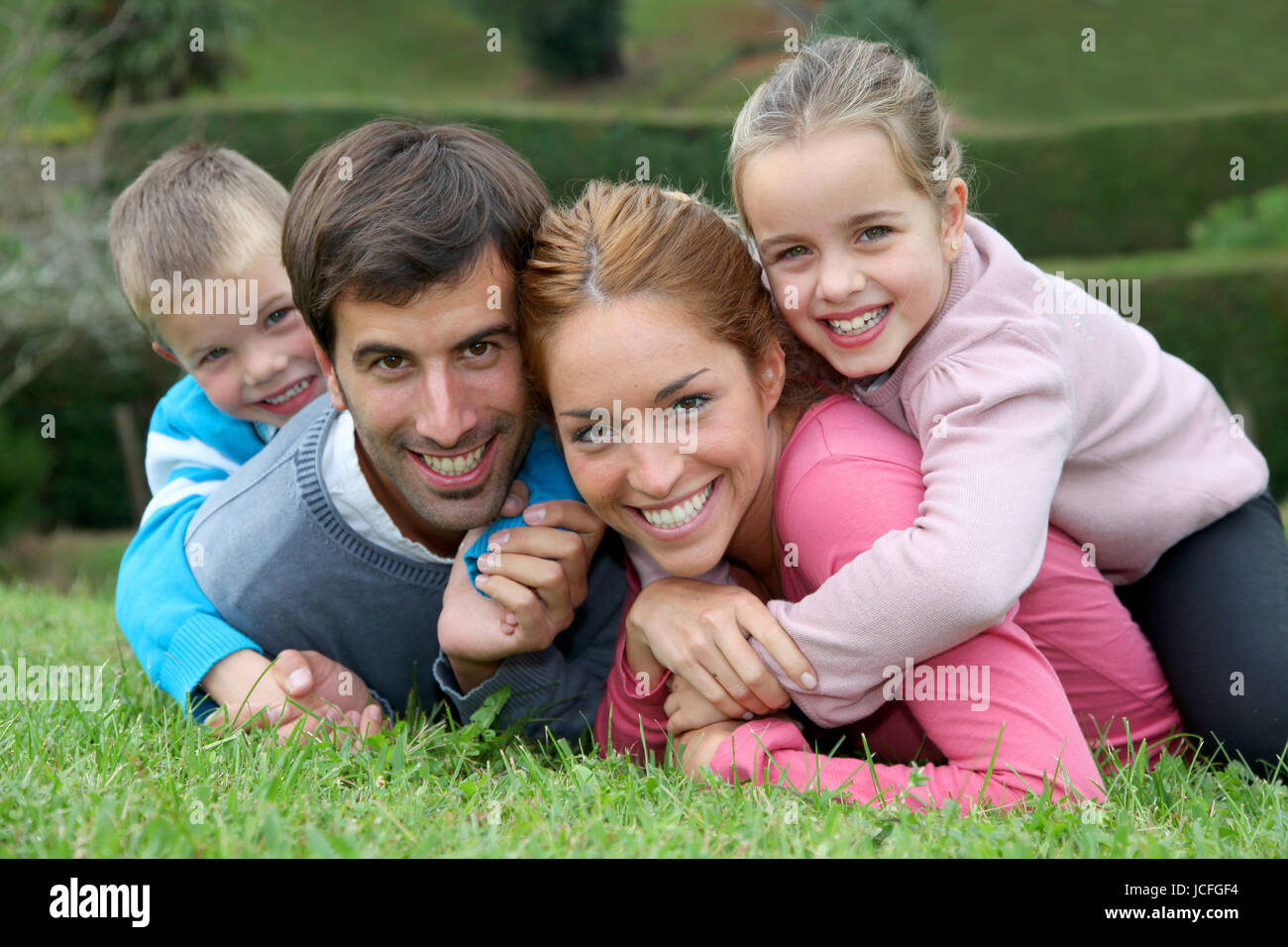Portrait of happy family lying down in grass Stock Photo - Alamy