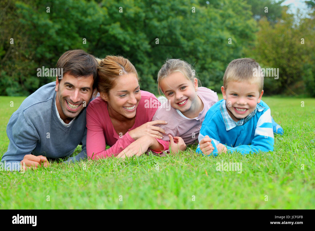 Portrait of happy family lying down in grass Stock Photo - Alamy