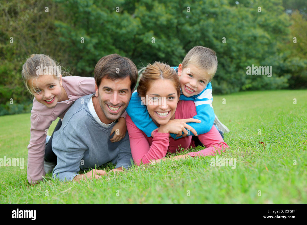 Portrait of happy family lying down in grass Stock Photo - Alamy