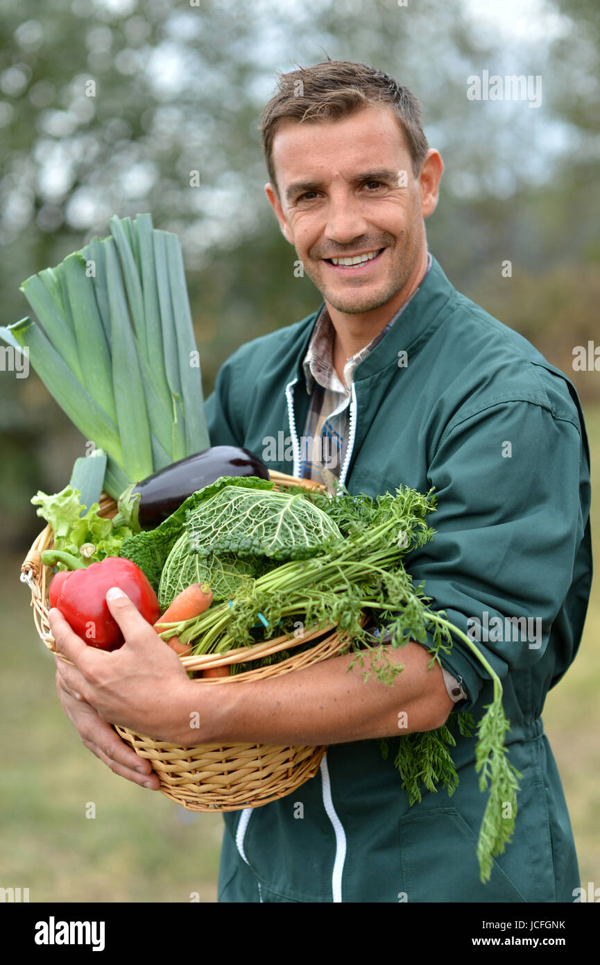 Portrait of smiling farmer holding vegetables basket Stock Photo - Alamy