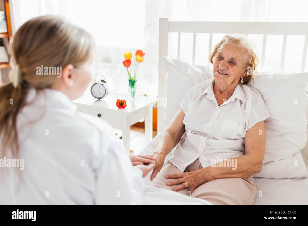 Providing care and support for elderly. Doctor visiting elderly patient at home. Stock Photo