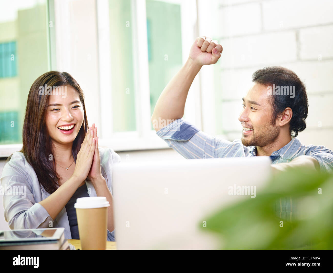 asian businessman and businesswoman celebrating success and achievement in office. Stock Photo