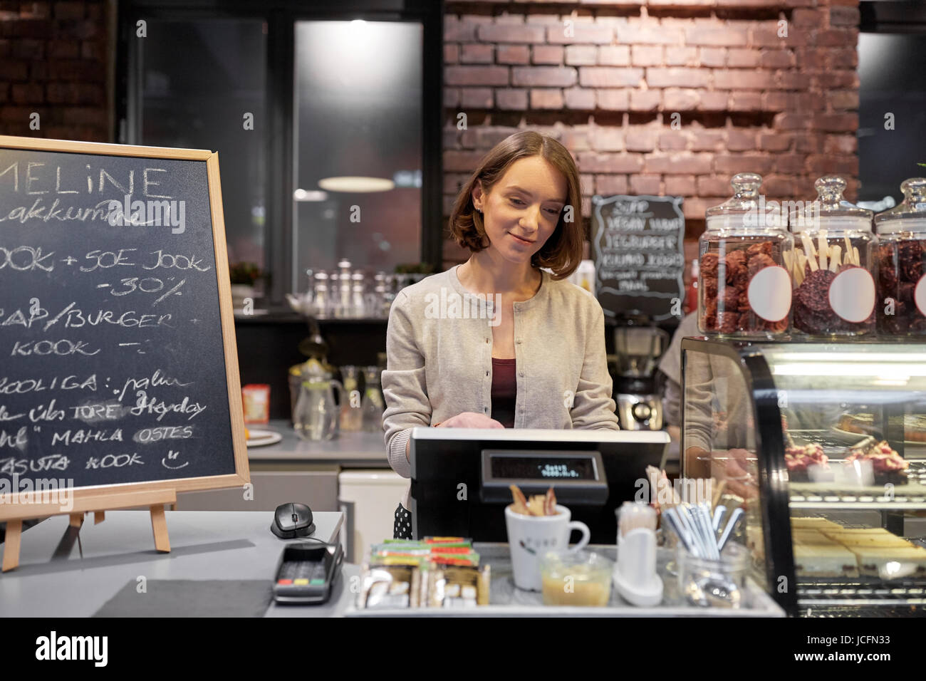 happy woman or barmaid with cashbox at cafe Stock Photo