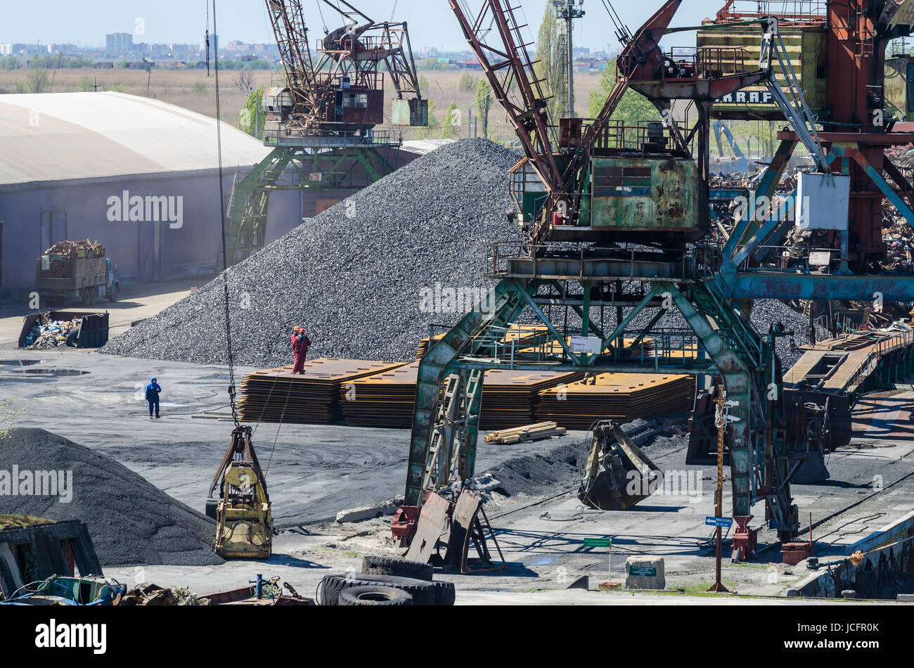 Crane in river port. Heavy cranes unloading metal to import. Steel delivery Stock Photo