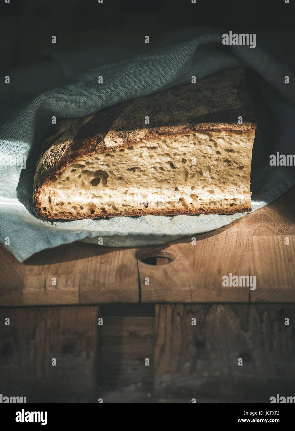 Rustic French rye bread loaf covered with kitchen towel over shabby ...