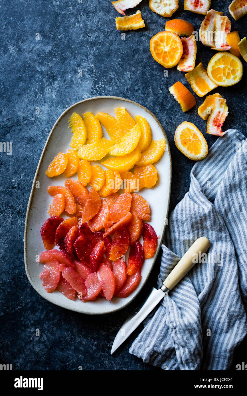 Various citrus fruits on a plate, all sliced and in segments Stock