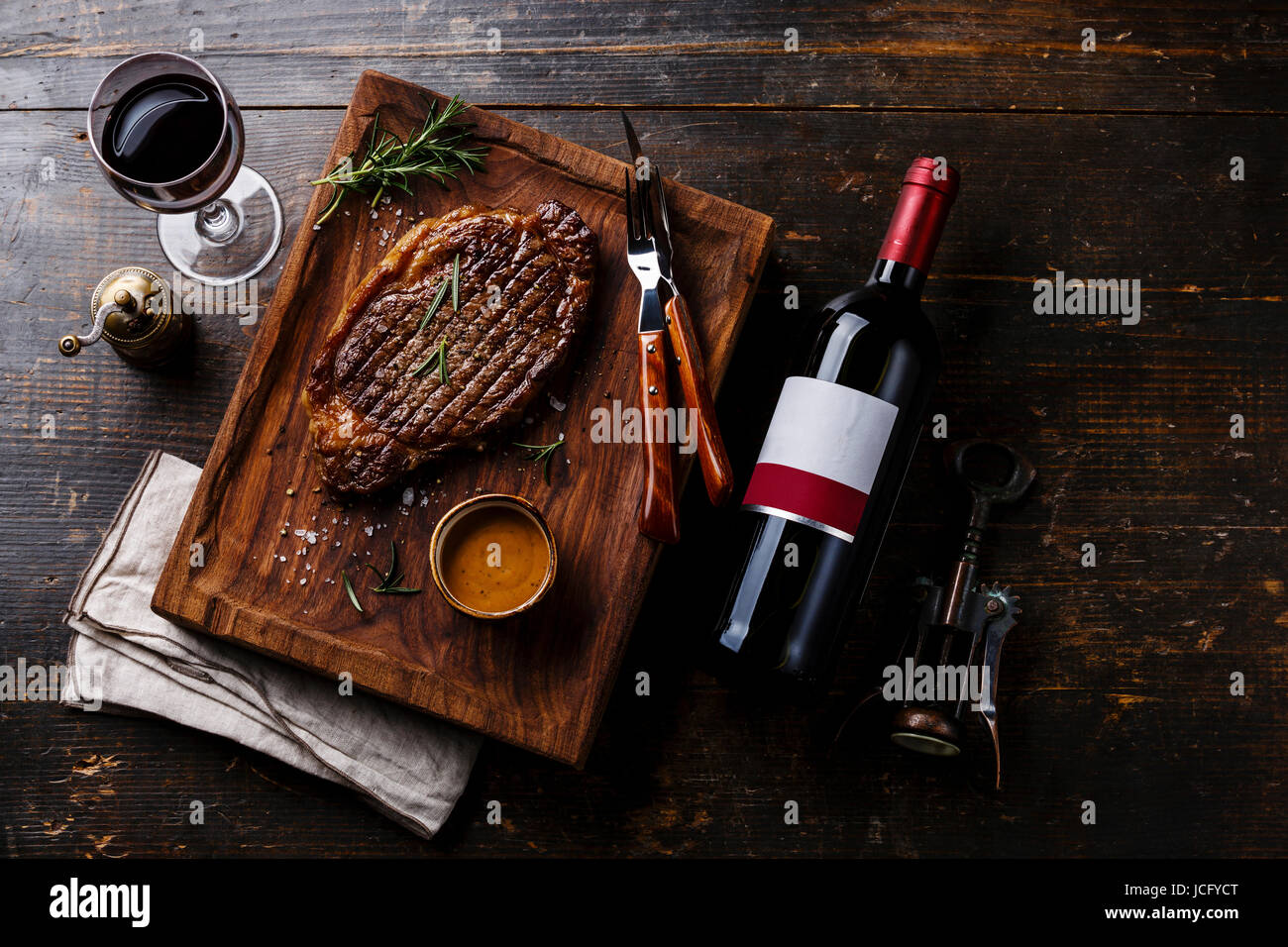 Grilled sliced Steak Rib eye with Pepper sauce and bottle of Red wine ...