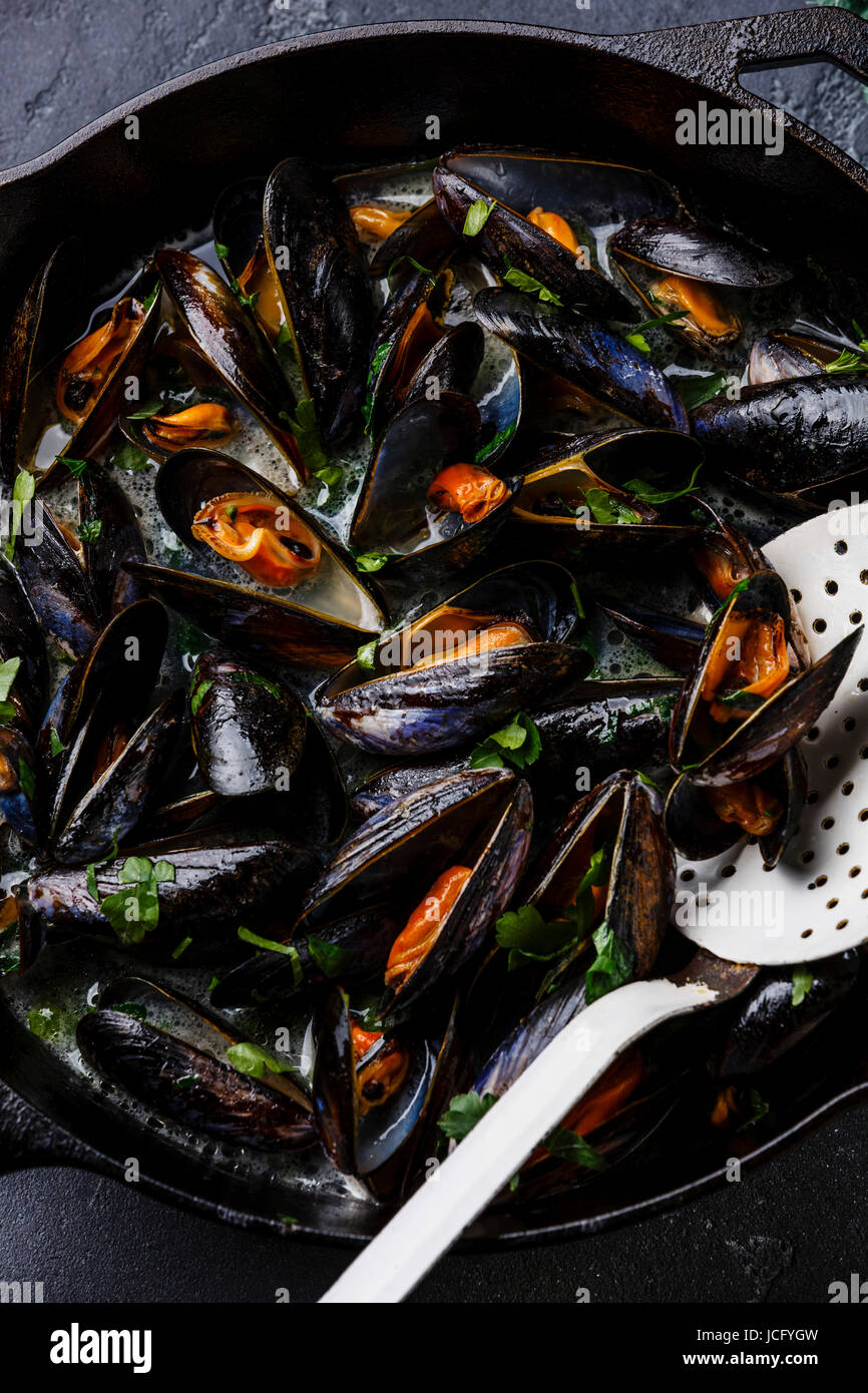 Mussels in black cooking pan with parsley close-up Stock Photo