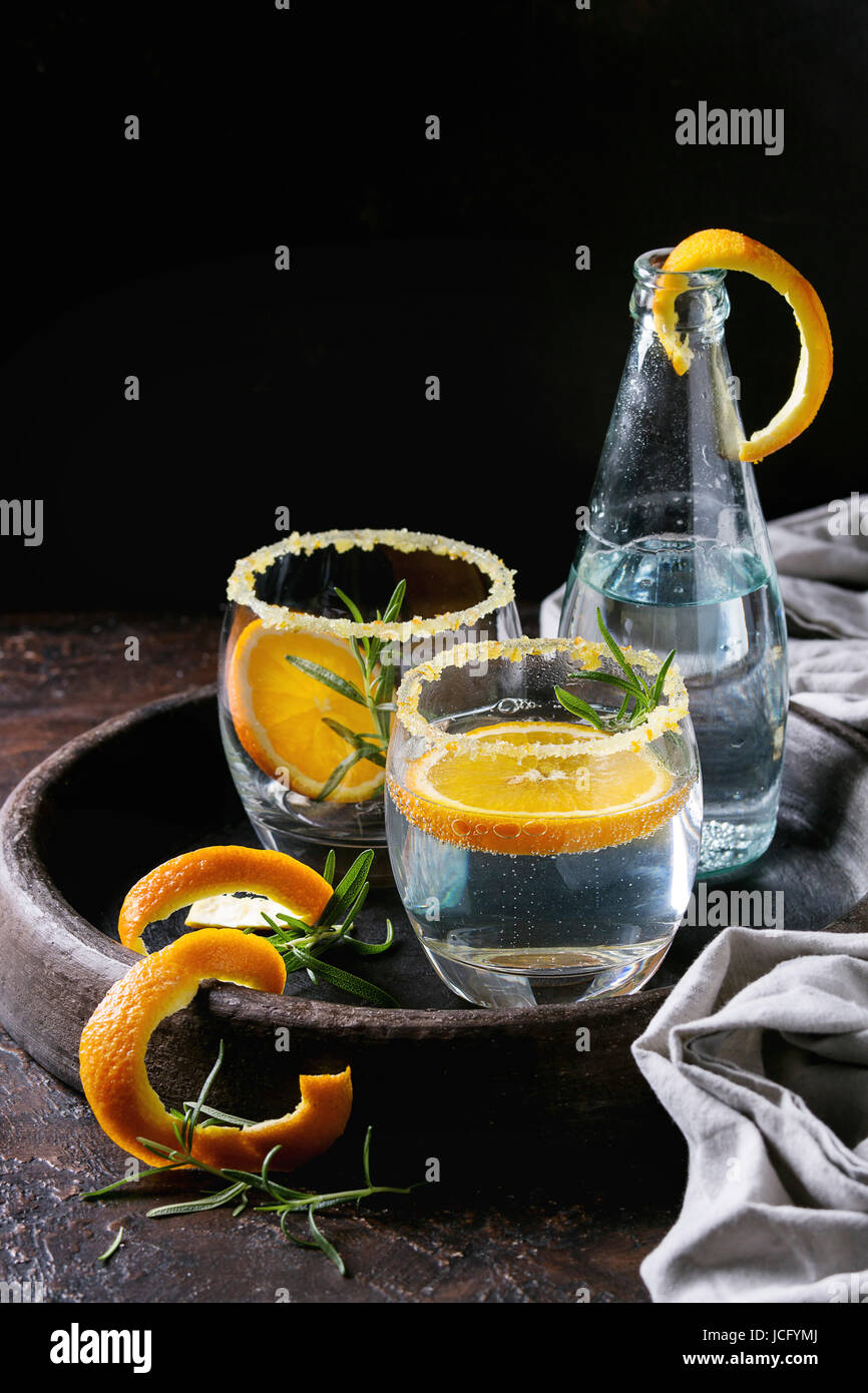 Tonic water cocktail with rosemary and orange. Two glasses and bottle
