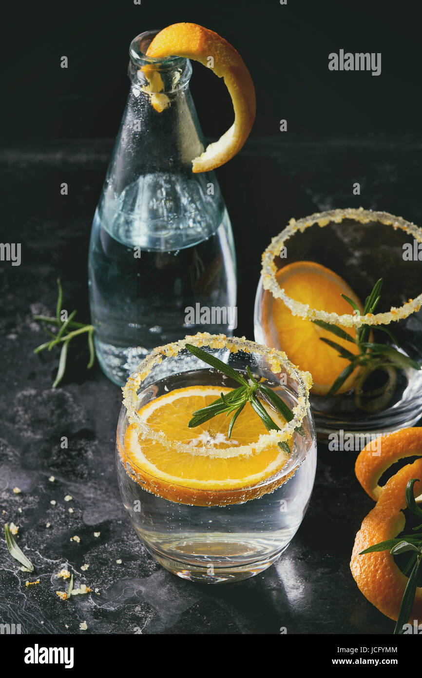 Tonic water cocktail with rosemary and orange. Two glasses and bottle