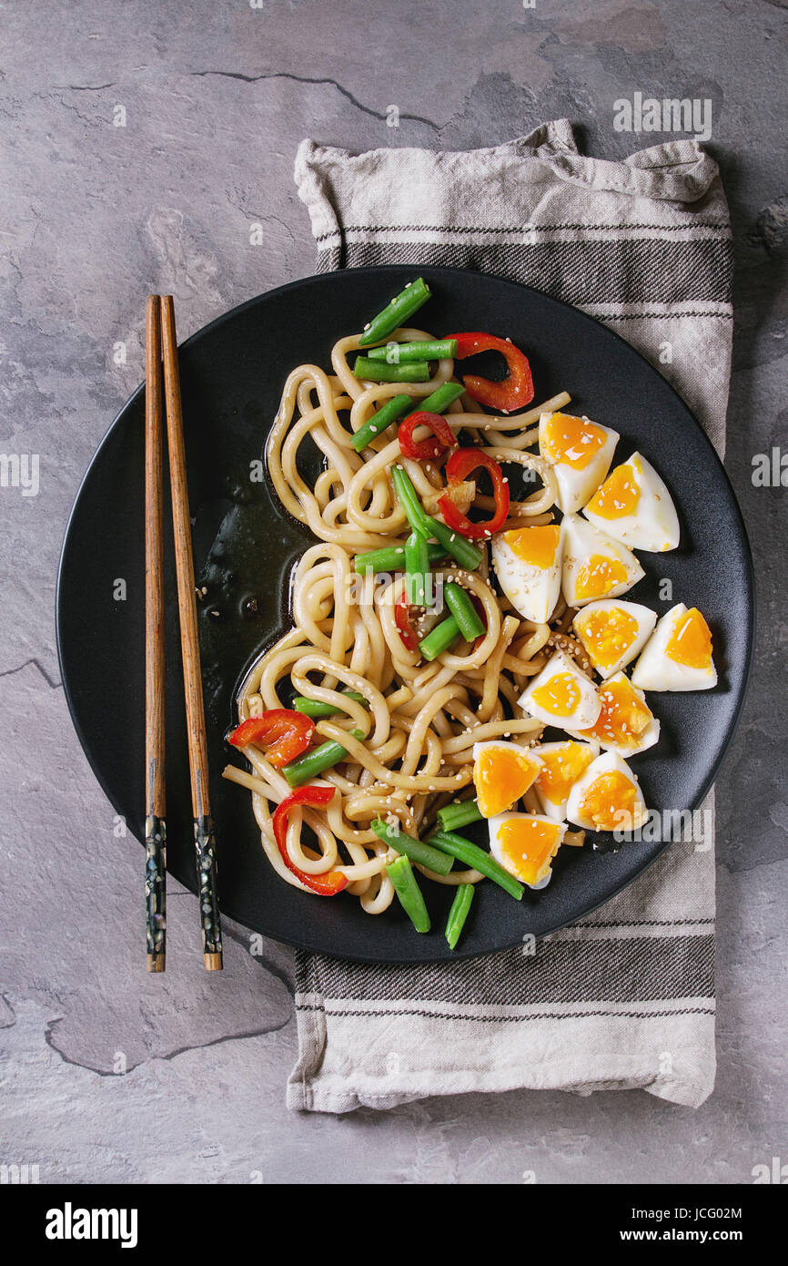 Cooking stir fry udon noodles, green beans, sliced paprika, boiled eggs
