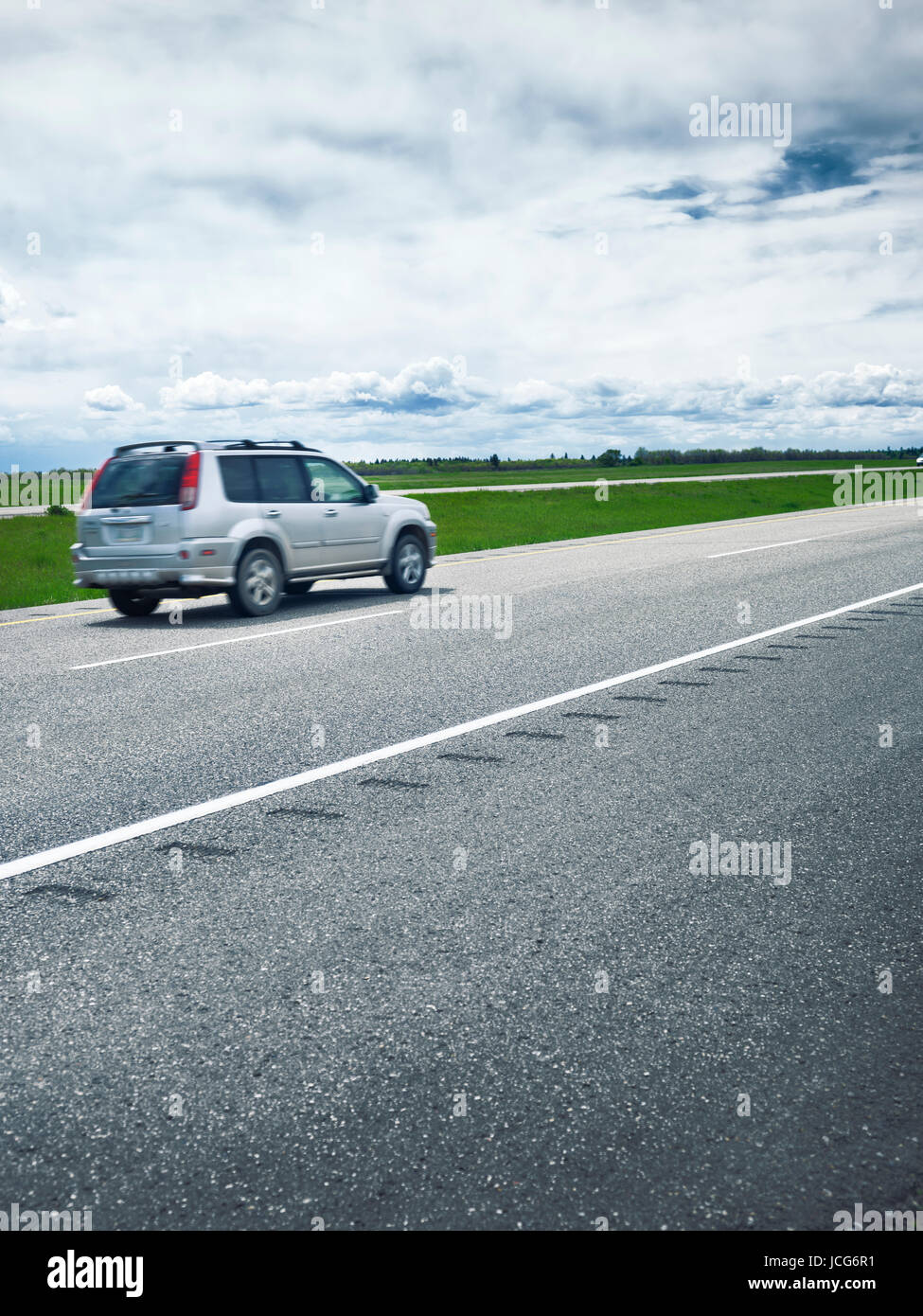 Moving single car on Trans-Canada highway traveling through Manitoba, outdoor scenery. Manitoba, Canada. Stock Photo