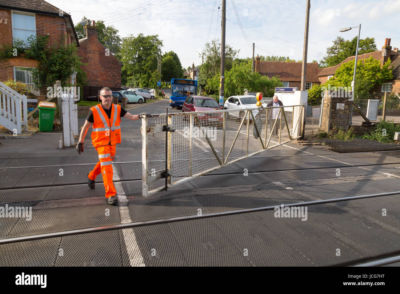 Railway worker opening the gates at a Manual level crossing, Chartham, Kent England UK Stock Photo