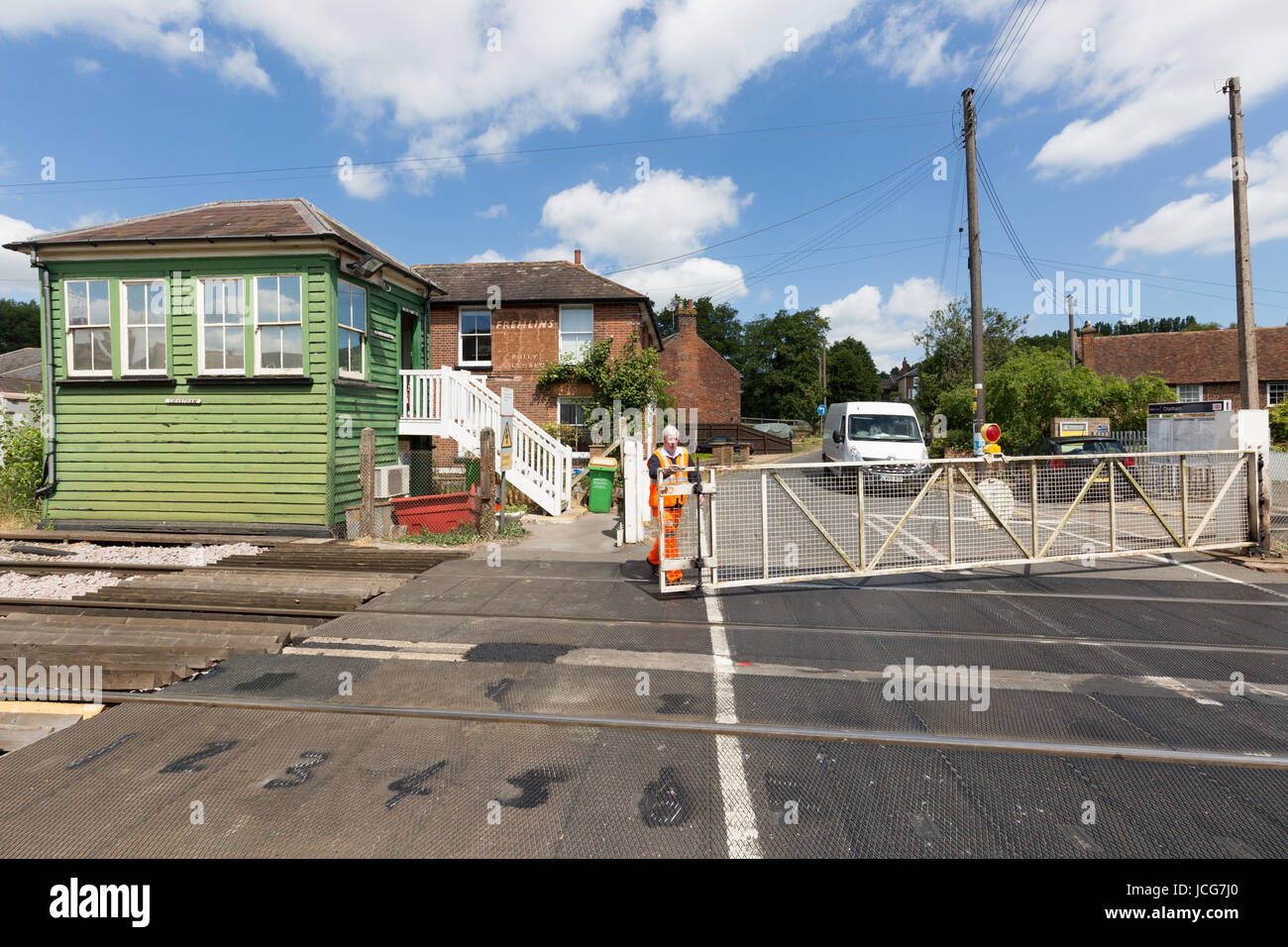 Railway worker opening the gates at a Manual level crossing, Chartham, Kent England UK Stock Photo