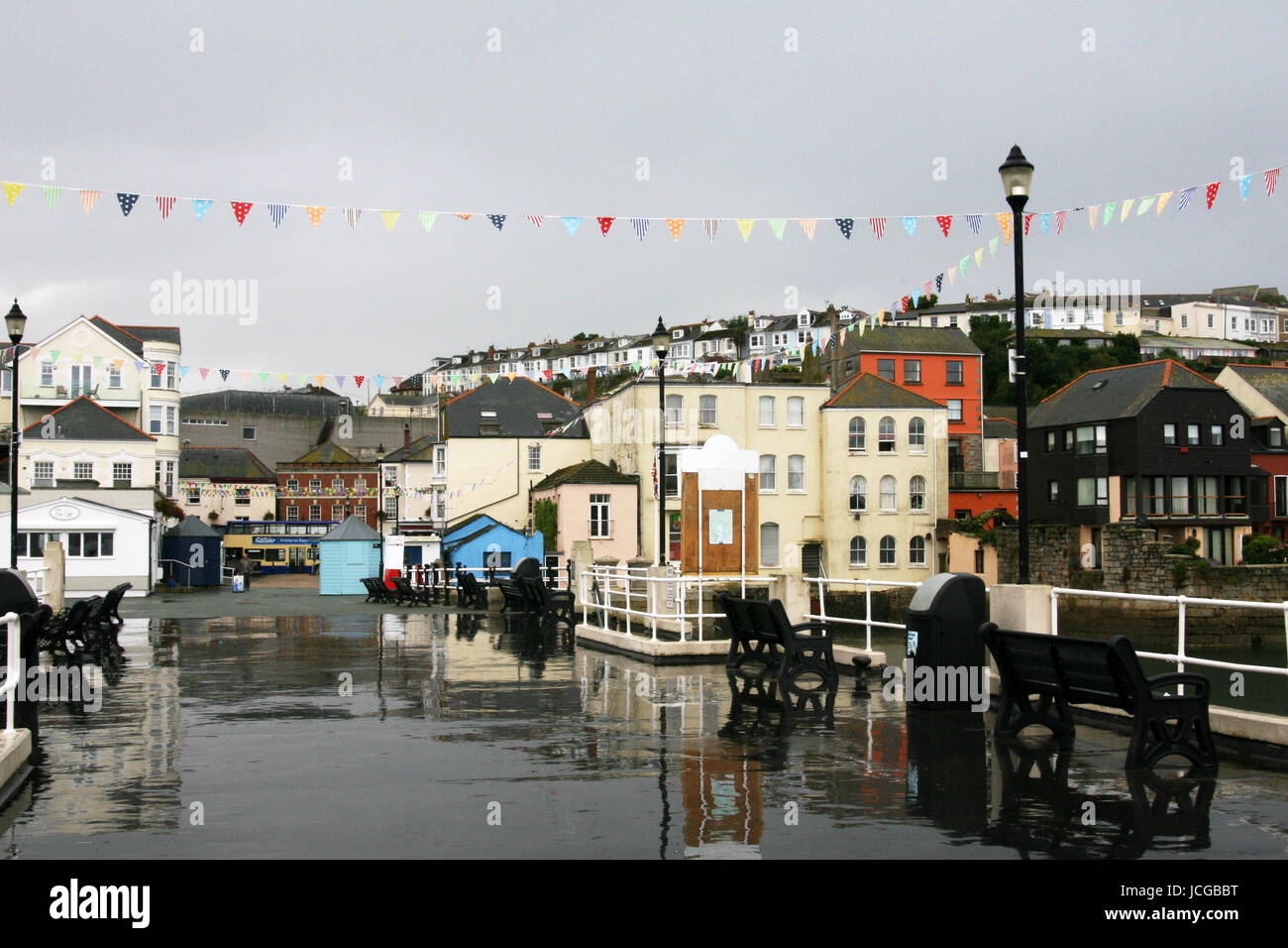 A wet Falmouth pier with flags on a bright but rainy day as the sunshine trying to come out Stock Photo