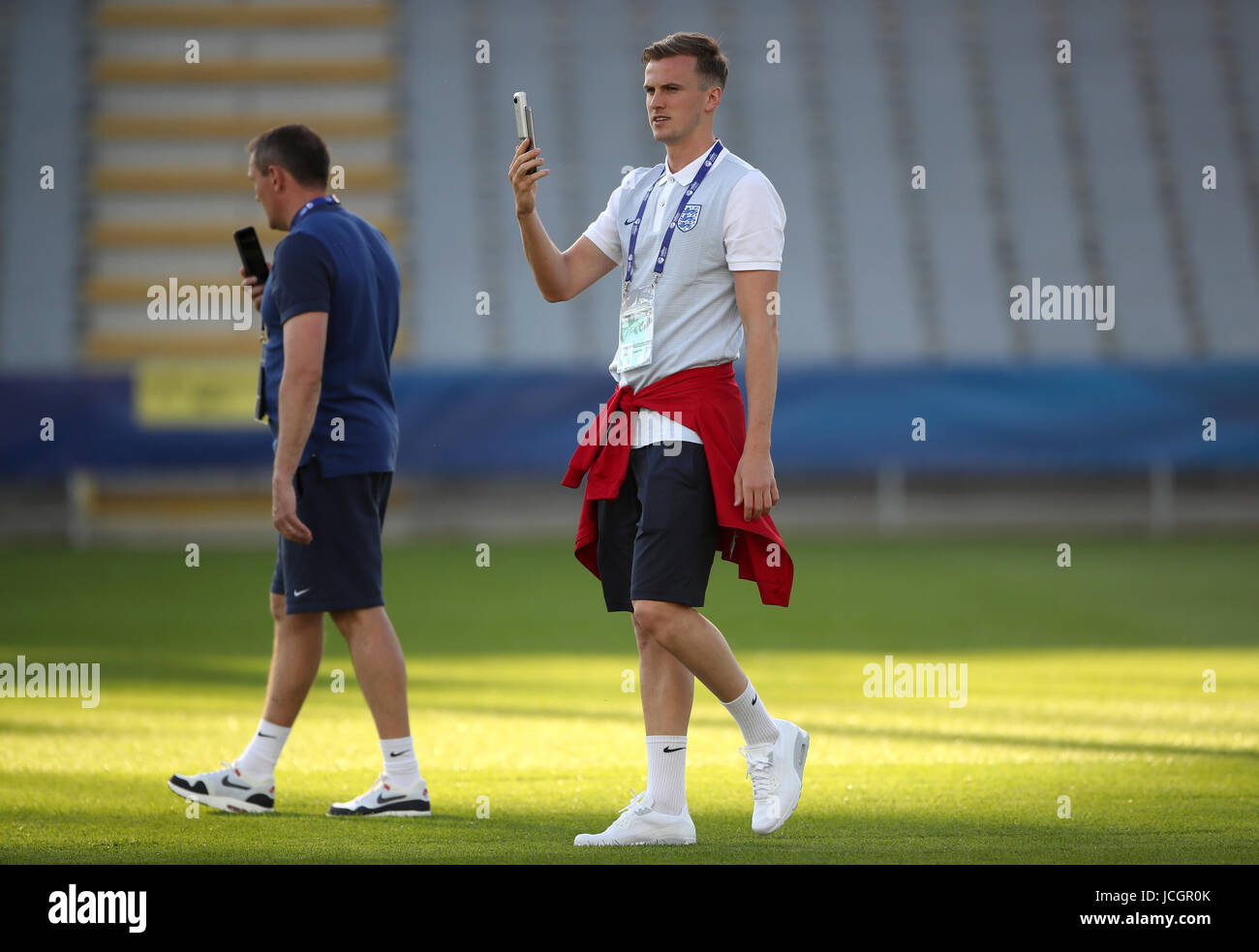 England U21 manager Aidy Boothroyd (left) and Rob Holding on their mobile phones during the team walkaround at the Kolporter Arena in Kielce, Poland. Stock Photo